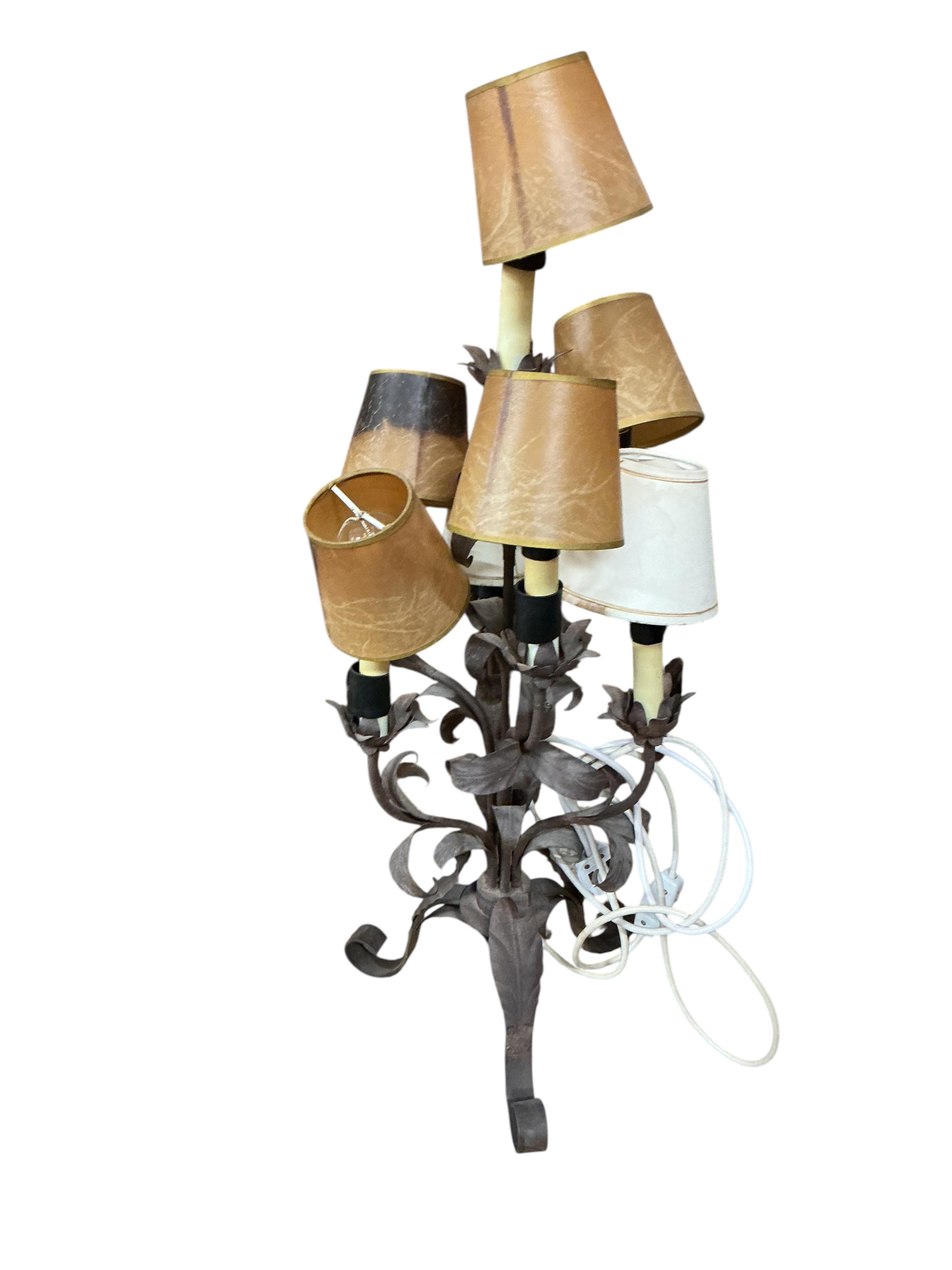 A pair of wrought and embossed four branch, five light candelabra, height 94cm